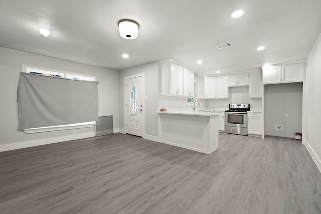 3624 Baylor St, Fort Worth, TX 76119 - kitchen featuring stainless steel electric stove, a peninsula, white cabinets, light countertops, and recessed lighting