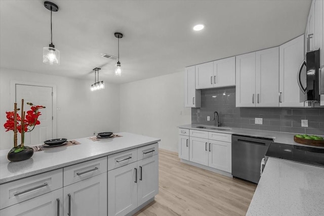7302 Vista Cliff Dr, Fort Worth, TX 76179 - kitchen featuring dishwasher, black microwave, white cabinets, decorative backsplash, and light wood-style floors