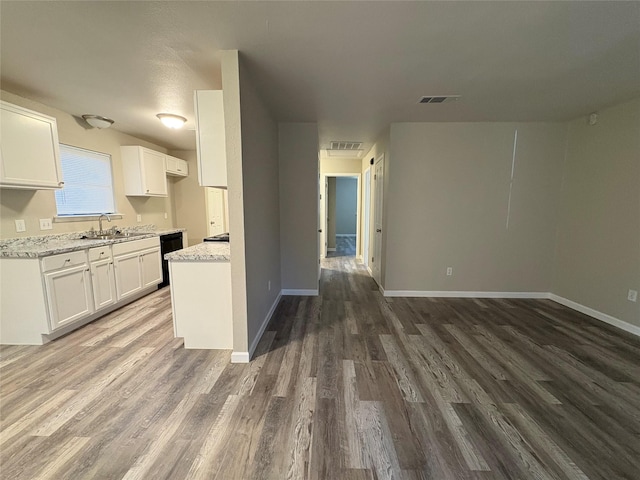 2209 Viewtop Ln Unit 2, Arlington, TX 76012 - kitchen featuring dishwasher, wood finished floors, white cabinetry, and light stone countertops
