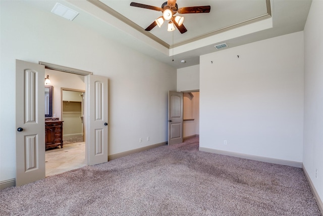 2204 Hartley Dr, Forney, TX 75126 - unfurnished bedroom featuring light colored carpet, a tray ceiling, a walk in closet, crown molding, and a high ceiling