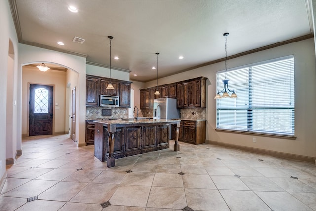 2204 Hartley Dr, Forney, TX 75126 - kitchen featuring stainless steel appliances, ornamental molding, arched walkways, decorative backsplash, and dark brown cabinetry