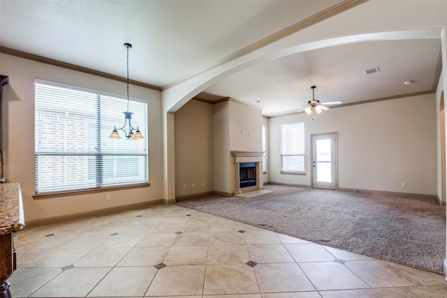 2204 Hartley Dr, Forney, TX 75126 - unfurnished living room featuring ceiling fan, arched walkways, light tile patterned floors, ornamental molding, and light colored carpet