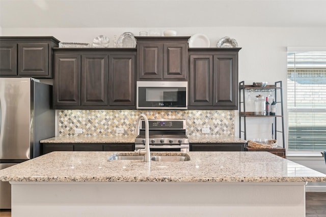 8901 Thompson Rd, Argyle, TX 76226 - kitchen with appliances with stainless steel finishes, tasteful backsplash, light stone counters, and dark brown cabinetry