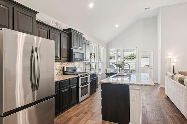 8901 Thompson Rd, Argyle, TX 76226 - kitchen featuring stainless steel appliances, backsplash, high vaulted ceiling, open floor plan, and a center island with sink