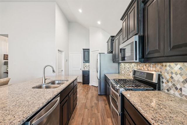 8901 Thompson Rd, Argyle, TX 76226 - kitchen with stainless steel appliances, light wood-style floors, decorative backsplash, recessed lighting, and light stone countertops