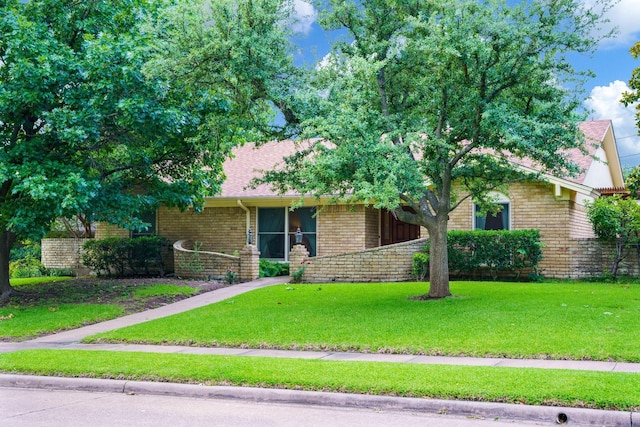 315 Ridgewood Dr, Richardson, TX 75080 - view of front of house featuring brick siding, a front yard, and a shingled roof