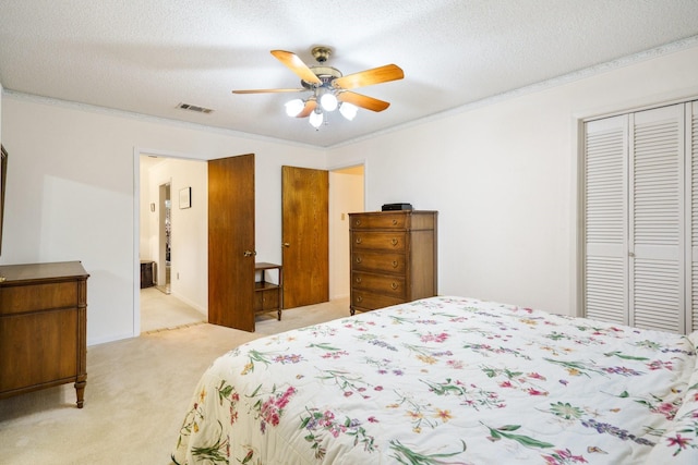 315 Ridgewood Dr, Richardson, TX 75080 - bedroom with a closet, light carpet, ornamental molding, ceiling fan, and a textured ceiling