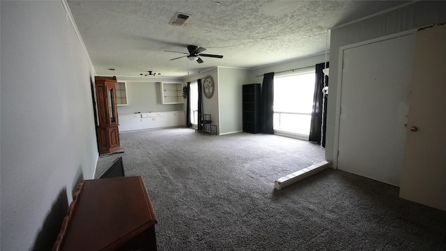 1819 Panhandle St, Denton, TX 76201 - unfurnished living room featuring ceiling fan, carpet, and a textured ceiling