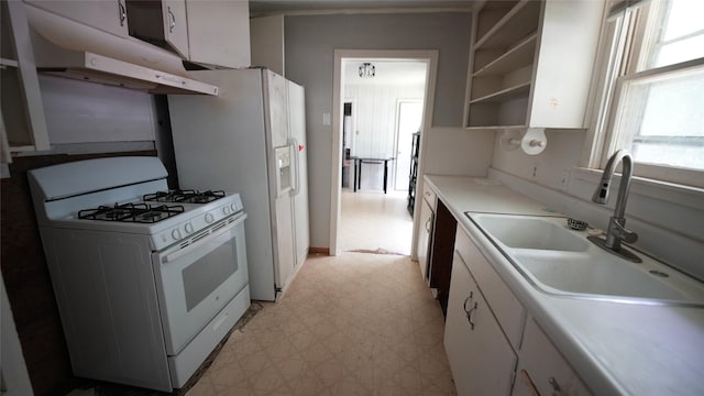 1819 Panhandle St, Denton, TX 76201 - kitchen featuring white gas range oven, under cabinet range hood, light floors, and white cabinets