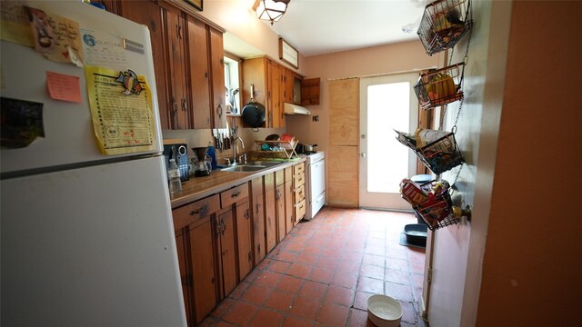 811 Crescent St, Denton, TX 76201 - kitchen featuring white appliances, under cabinet range hood, brown cabinetry, and light countertops