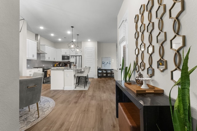 711 Prairie Falcon Dr, Arlington, TX 76005 - kitchen featuring appliances with stainless steel finishes, white cabinetry, a kitchen island with sink, decorative backsplash, and a kitchen bar