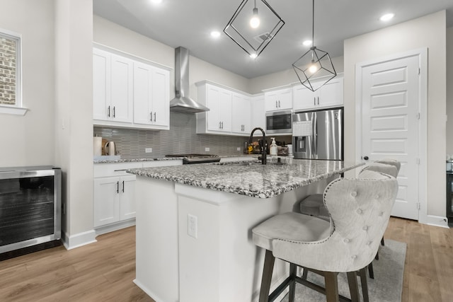 711 Prairie Falcon Dr, Arlington, TX 76005 - kitchen featuring stainless steel appliances, beverage cooler, wall chimney exhaust hood, decorative backsplash, and white cabinets