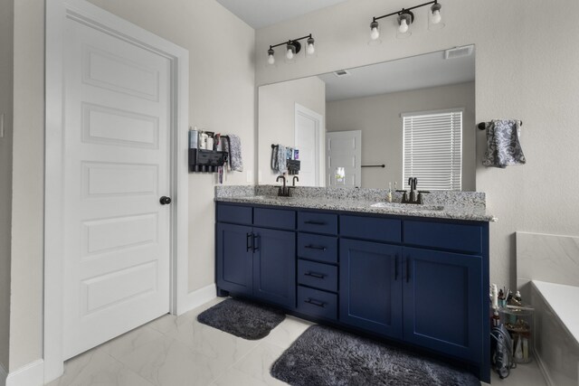 711 Prairie Falcon Dr, Arlington, TX 76005 - full bathroom featuring double vanity, marble finish flooring, and a bathtub
