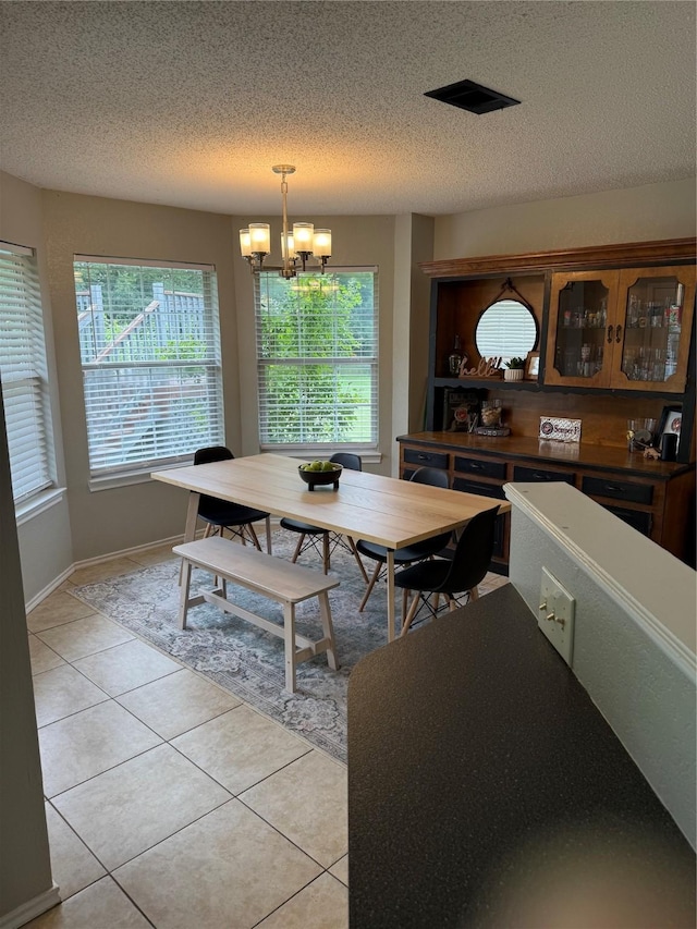 907 Dogwood St, Waco, TX 76706 - dining space featuring a chandelier, plenty of natural light, light tile patterned floors, and a textured ceiling