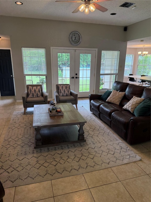 907 Dogwood St, Waco, TX 76706 - living room featuring ceiling fan, light tile patterned floors, a textured ceiling, and a chandelier