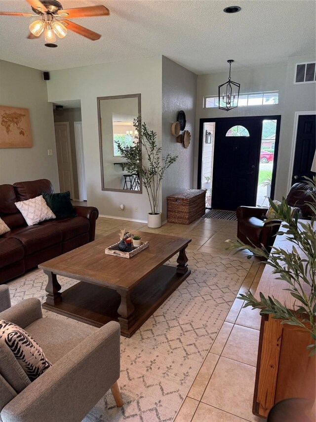 907 Dogwood St, Waco, TX 76706 - living area featuring light tile patterned floors, a textured ceiling, a chandelier, and a ceiling fan