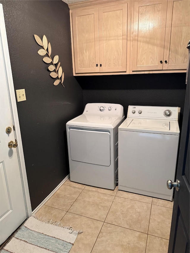 907 Dogwood St, Waco, TX 76706 - laundry room featuring separate washer and dryer, cabinet space, and light tile patterned flooring