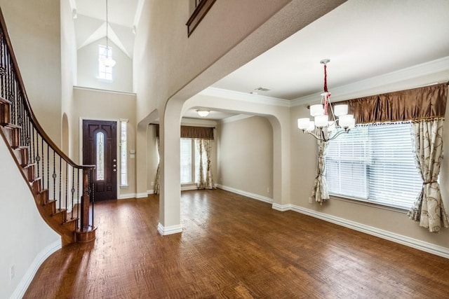 4517 Copeland Dr, Plano, TX 75024 - entryway with a chandelier, arched walkways, dark wood finished floors, stairway, and ornamental molding