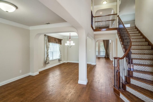 4517 Copeland Dr, Plano, TX 75024 - foyer entrance featuring arched walkways, a chandelier, stairway, wood finished floors, and crown molding