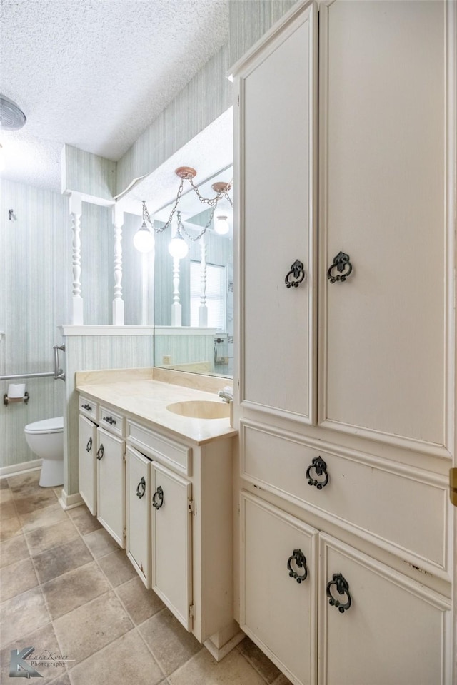 3826 Crest Way, Abilene, TX 79606 - bathroom featuring vanity, a textured ceiling, and wallpapered walls