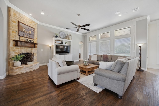 4513 Donnoli Dr, Flower Mound, TX 75022 - living room with arched walkways, ornamental molding, a ceiling fan, wood finished floors, and a stone fireplace