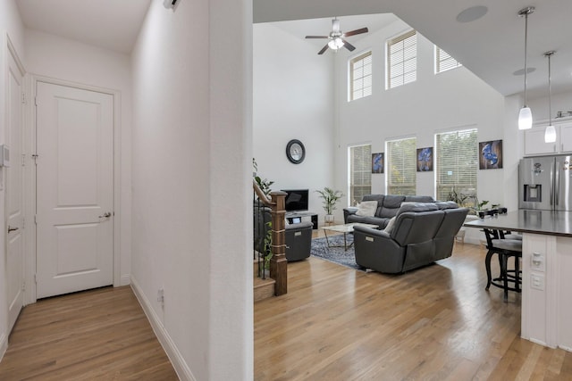 2464 Castle Ridge Dr, Richardson, TX 75080 - living area with light wood-style flooring, ceiling fan, and a high ceiling