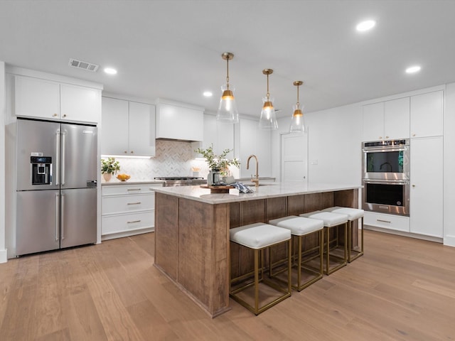 5832 Charlestown Dr, Dallas, TX 75230 - kitchen featuring stainless steel appliances, light wood-style flooring, backsplash, recessed lighting, and white cabinets