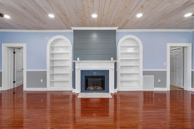 1301 W 2nd Ave, Corsicana, TX 75110 - unfurnished living room featuring built in shelves, crown molding, a fireplace, recessed lighting, and wood finished floors