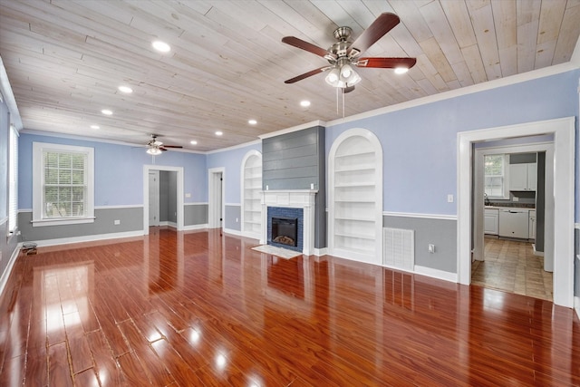 1301 W 2nd Ave, Corsicana, TX 75110 - unfurnished living room with a ceiling fan, wood ceiling, a fireplace with flush hearth, built in features, and wood finished floors