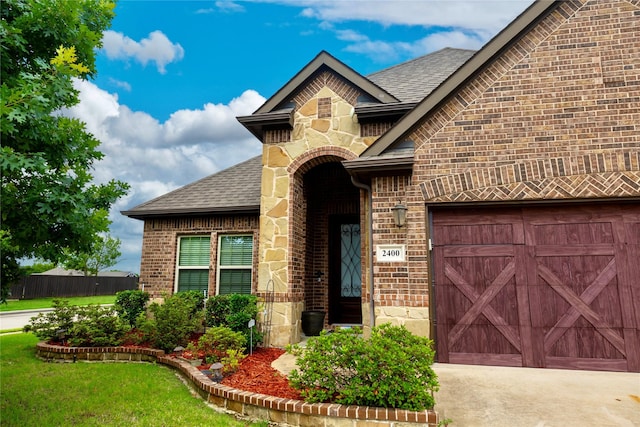 2400 Sabine Cir, Royse City, TX 75189 - view of front facade featuring brick siding, a garage, stone siding, and roof with shingles