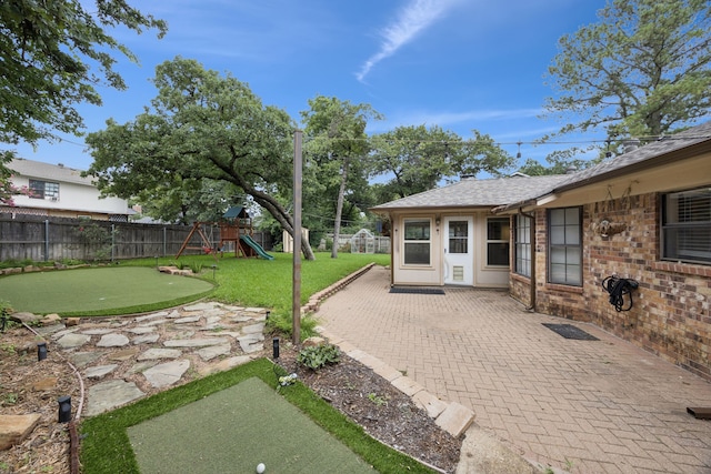 6209 Sierra Ct, Arlington, TX 76016 - fenced backyard featuring a putting green, a patio, and a playground
