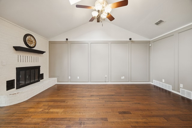 6209 Sierra Ct, Arlington, TX 76016 - unfurnished living room with a decorative wall, a ceiling fan, vaulted ceiling, wood finished floors, and a brick fireplace