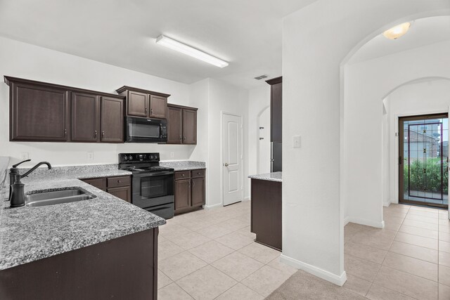 161 Collin St, Anna, TX 75409 - kitchen with black appliances, arched walkways, and light tile patterned flooring