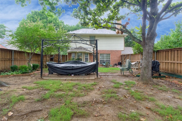 2315 Rockhill Rd, Mckinney, TX 75072 - back of property with a gazebo, brick siding, and a fenced backyard