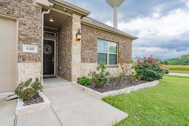 680 Navasota Dr, Crandall, TX 75114 - property entrance featuring a yard, brick siding, roof with shingles, and stone siding
