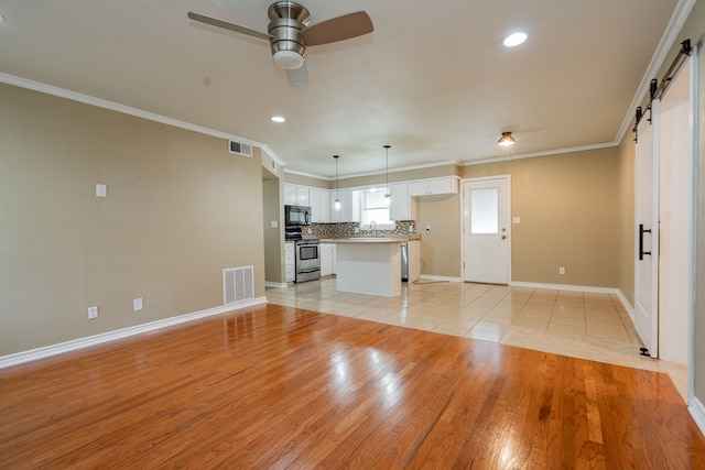 208 De Gail St, Grand Saline, TX 75140 - unfurnished living room with a barn door, light wood finished floors, ceiling fan, ornamental molding, and recessed lighting