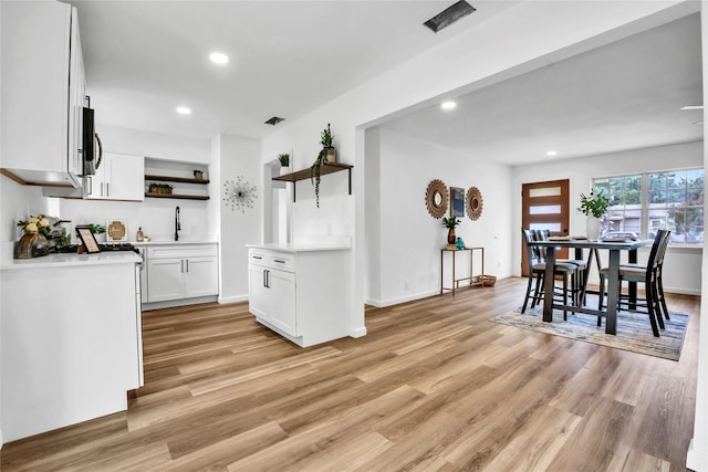 108 Fannin Dr, Euless, TX 76039 - kitchen featuring open shelves, light wood-style flooring, light countertops, white cabinets, and recessed lighting