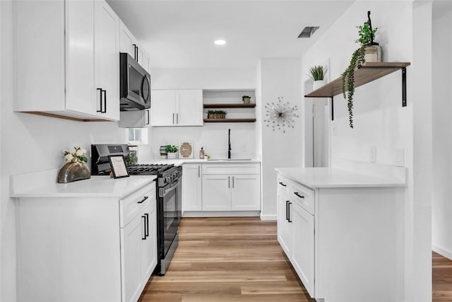 108 Fannin Dr, Euless, TX 76039 - kitchen with open shelves, stainless steel appliances, light wood-style flooring, white cabinets, and recessed lighting
