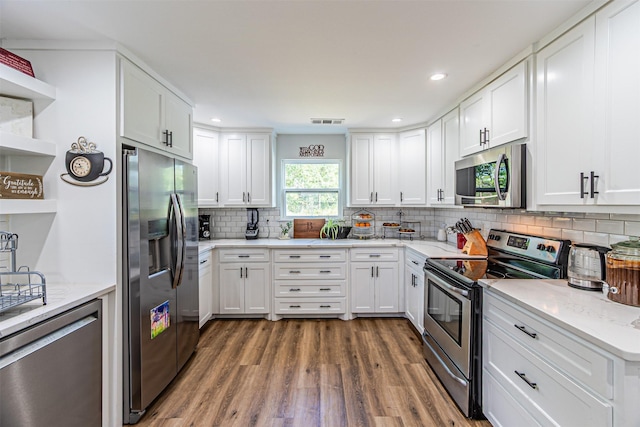 3135 Brazos River Dr, Granbury, TX 76048 - kitchen featuring appliances with stainless steel finishes, open shelves, wood finished floors, white cabinetry, and recessed lighting