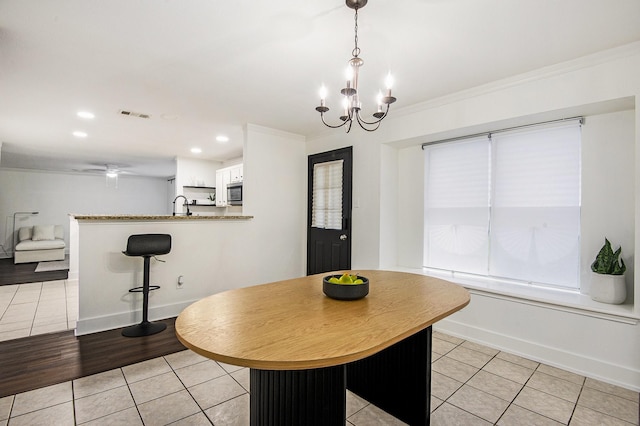 6833 Permian Ln, Fort Worth, TX 76137 - dining area featuring light tile patterned floors, a chandelier, ornamental molding, and recessed lighting