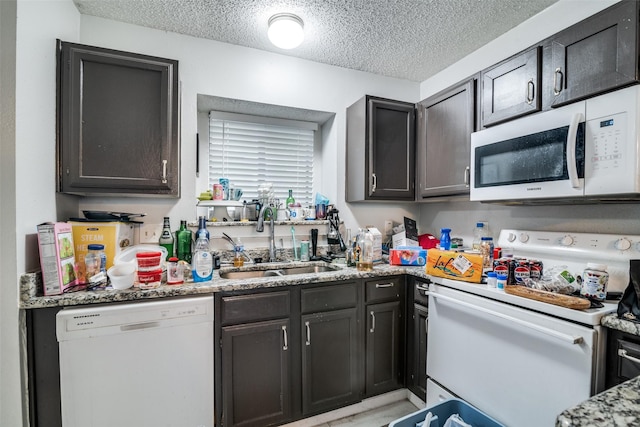 1612 Hackamore St, Mesquite, TX 75149 - kitchen featuring white appliances, a textured ceiling, and light stone countertops