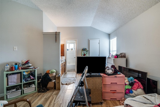 1612 Hackamore St, Mesquite, TX 75149 - bedroom with vaulted ceiling, light wood-style floors, a textured ceiling, and ensuite bathroom