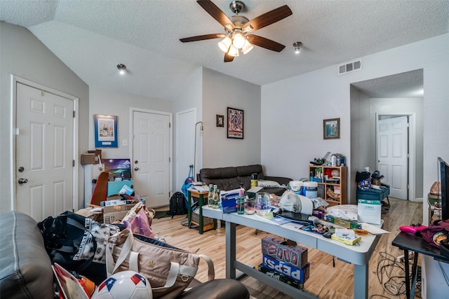 1612 Hackamore St, Mesquite, TX 75149 - living room featuring light wood-type flooring, ceiling fan, lofted ceiling, and a textured ceiling