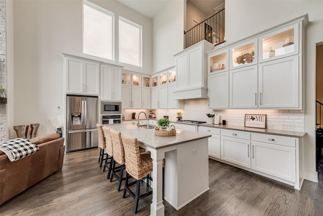 3900 Brazoria Dr, Prosper, TX 75078 - kitchen featuring stainless steel appliances, a high ceiling, a kitchen bar, tasteful backsplash, and dark wood-style floors