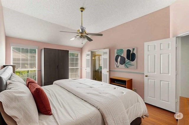 2705 Willowood Dr, Grapevine, TX 76051 - bedroom featuring lofted ceiling, multiple windows, wood finished floors, a textured ceiling, and a ceiling fan