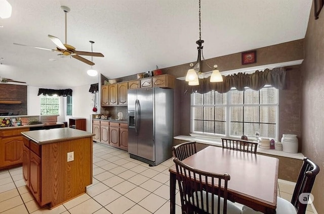 2705 Willowood Dr, Grapevine, TX 76051 - kitchen with stainless steel fridge with ice dispenser, ceiling fan, vaulted ceiling, a center island, and light tile patterned floors
