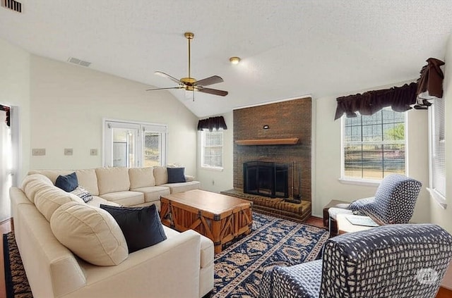 2705 Willowood Dr, Grapevine, TX 76051 - living area featuring ceiling fan, a fireplace, lofted ceiling, wood finished floors, and a textured ceiling