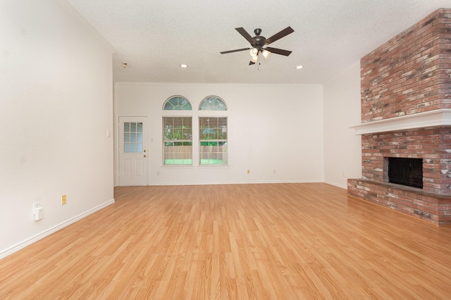 2515 High Pointe Blvd, Mckinney, TX 75071 - unfurnished living room with ceiling fan, wood finished floors, a brick fireplace, a textured ceiling, and recessed lighting