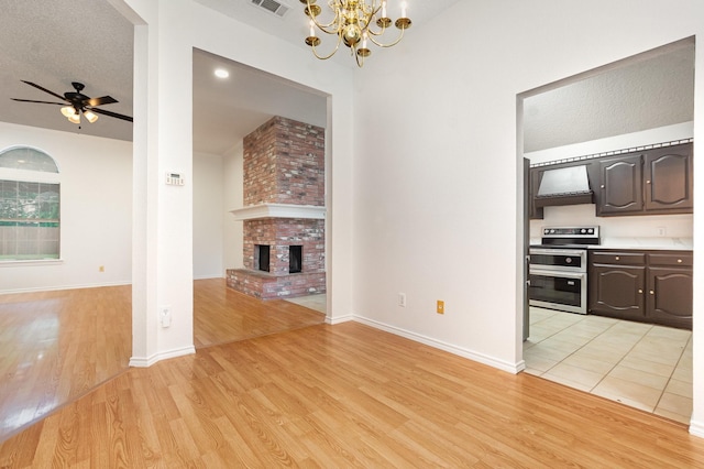 2515 High Pointe Blvd, Mckinney, TX 75071 - unfurnished living room featuring light wood finished floors, a brick fireplace, ceiling fan, and a chandelier