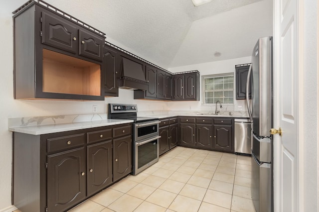 2515 High Pointe Blvd, Mckinney, TX 75071 - kitchen with stainless steel appliances, premium range hood, dark brown cabinets, light tile patterned floors, and lofted ceiling